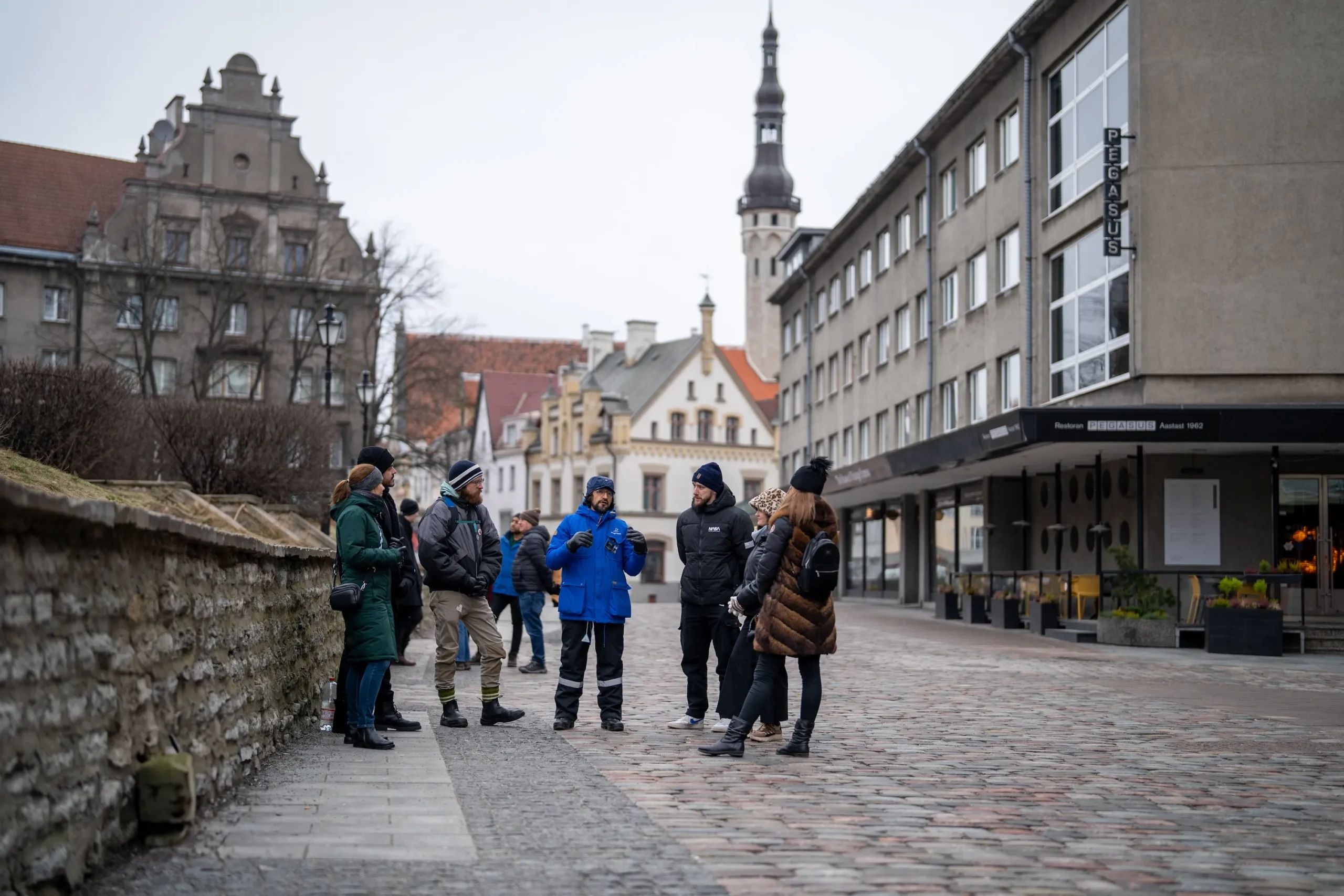 Guide explaining Tallinn Old Town history to a group of tourists during a walking tour