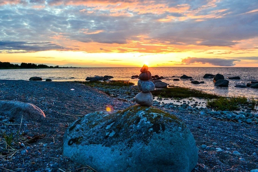 Sunset over the Baltic Sea on Prangli Island with stone stack on the beach