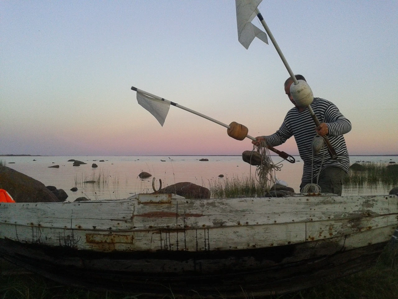 Local fisherman preparing fishing gear on the Baltic Sea coast during calm evening weather in Estonia.