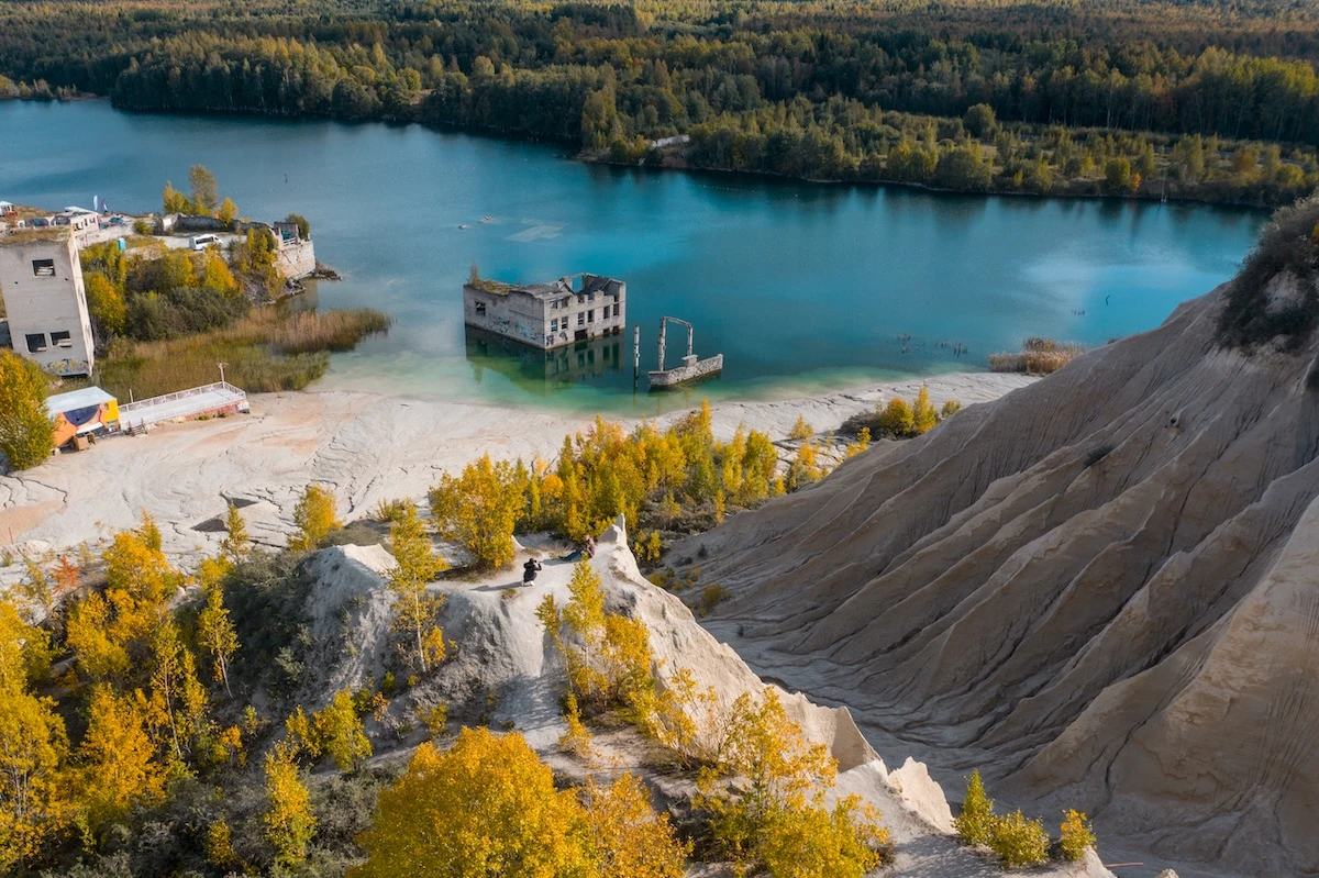 Autumn landscape with golden trees around Rummu quarry during seasonal weather in Estonia.