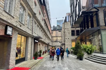 Group walking through a narrow street lined with restored stone warehouses in Rotermann