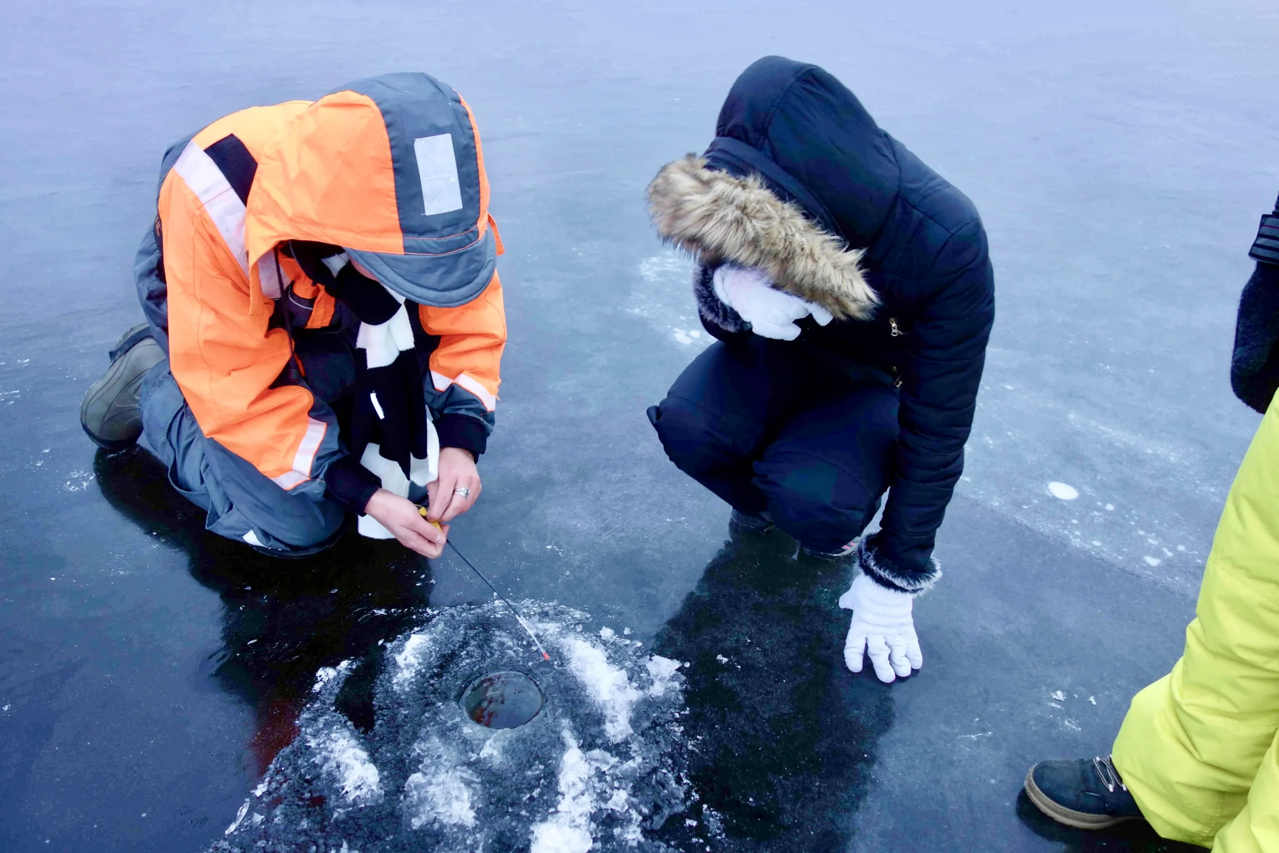 Ice fishing on a frozen Estonian lake during a winter tour near Tallinn.