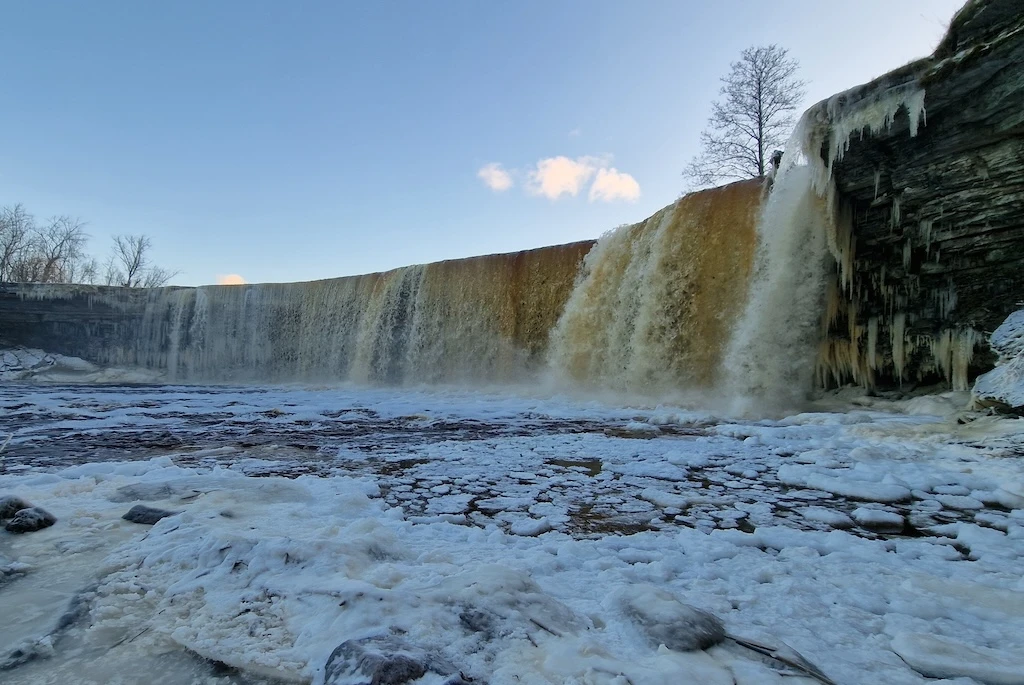 Jägala waterfall in winter with ice formations and frozen river surface in Estonia