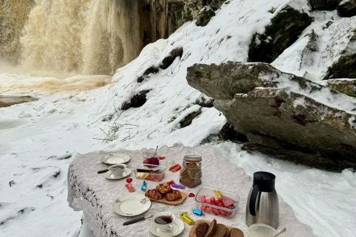 Winter picnic at snowy Jägala Waterfall with hot drinks and Estonian treats.