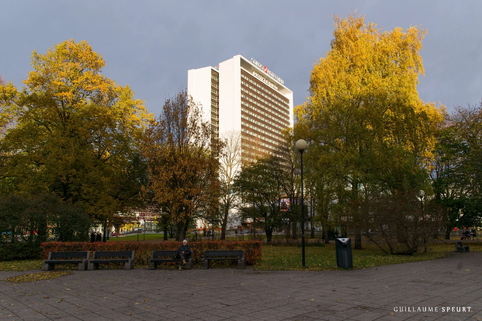 Hotel Viru in Tallinn seen through autumn park trees, a tall modernist building from the Soviet era