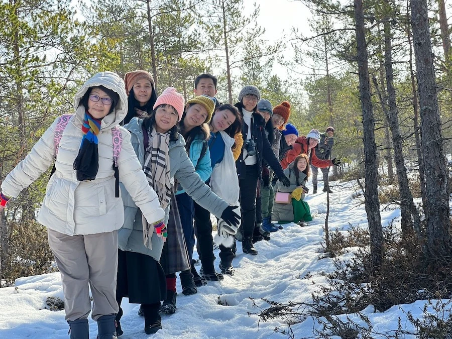 Visitors walking on a snowy forest trail in Lahemaa National Park during early spring.