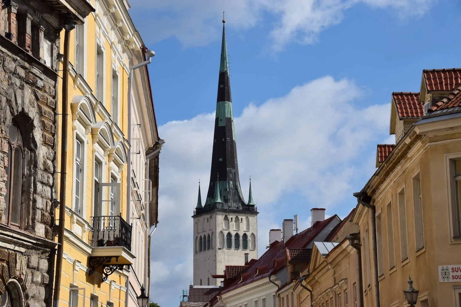 St Olaf's Church spire rising above a narrow street of historic buildings in Tallinn Old Town